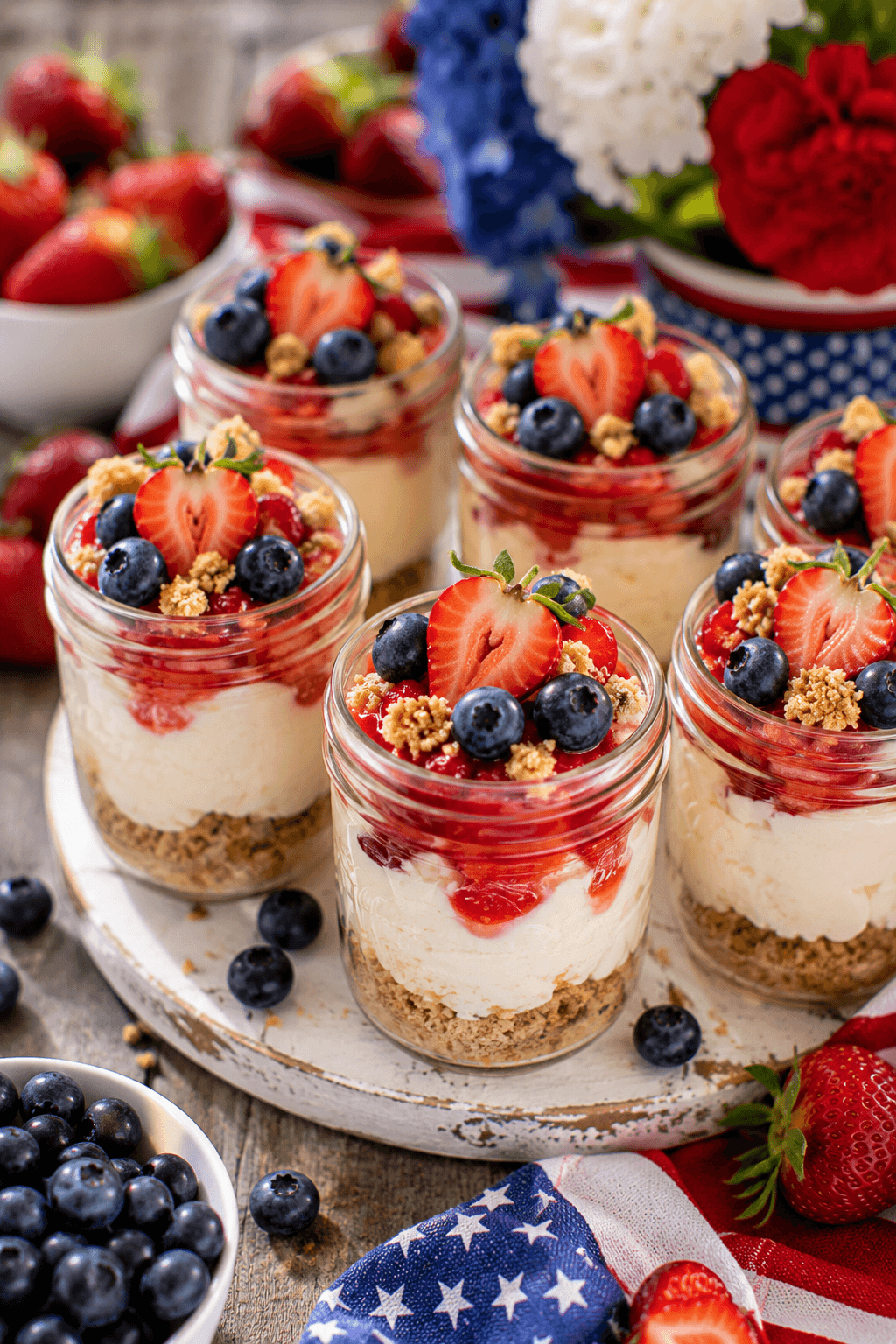 Individual cheesecake jars topped with strawberries and blueberries
